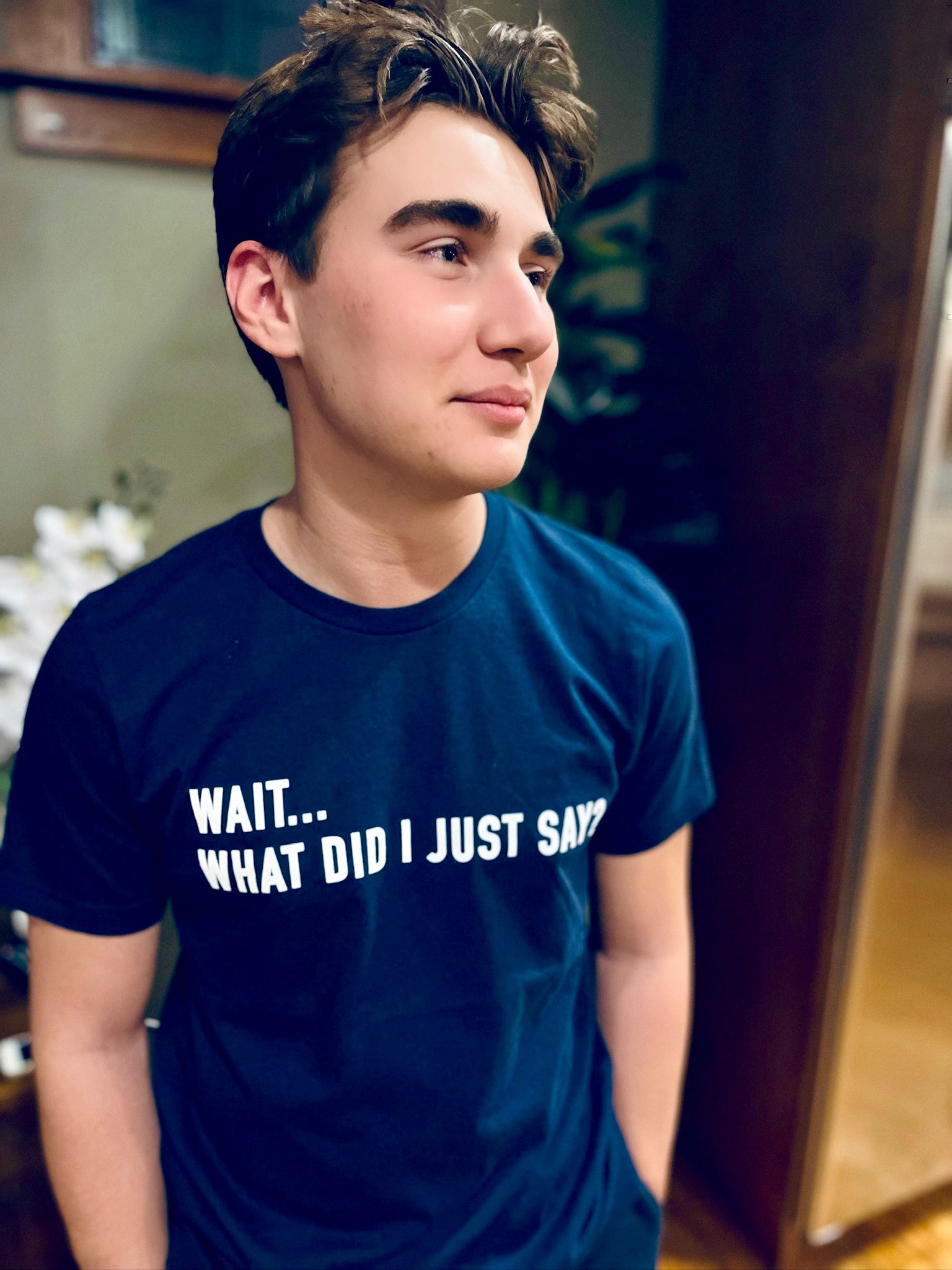 Person wearing a navy blue t-shirt with text indoors