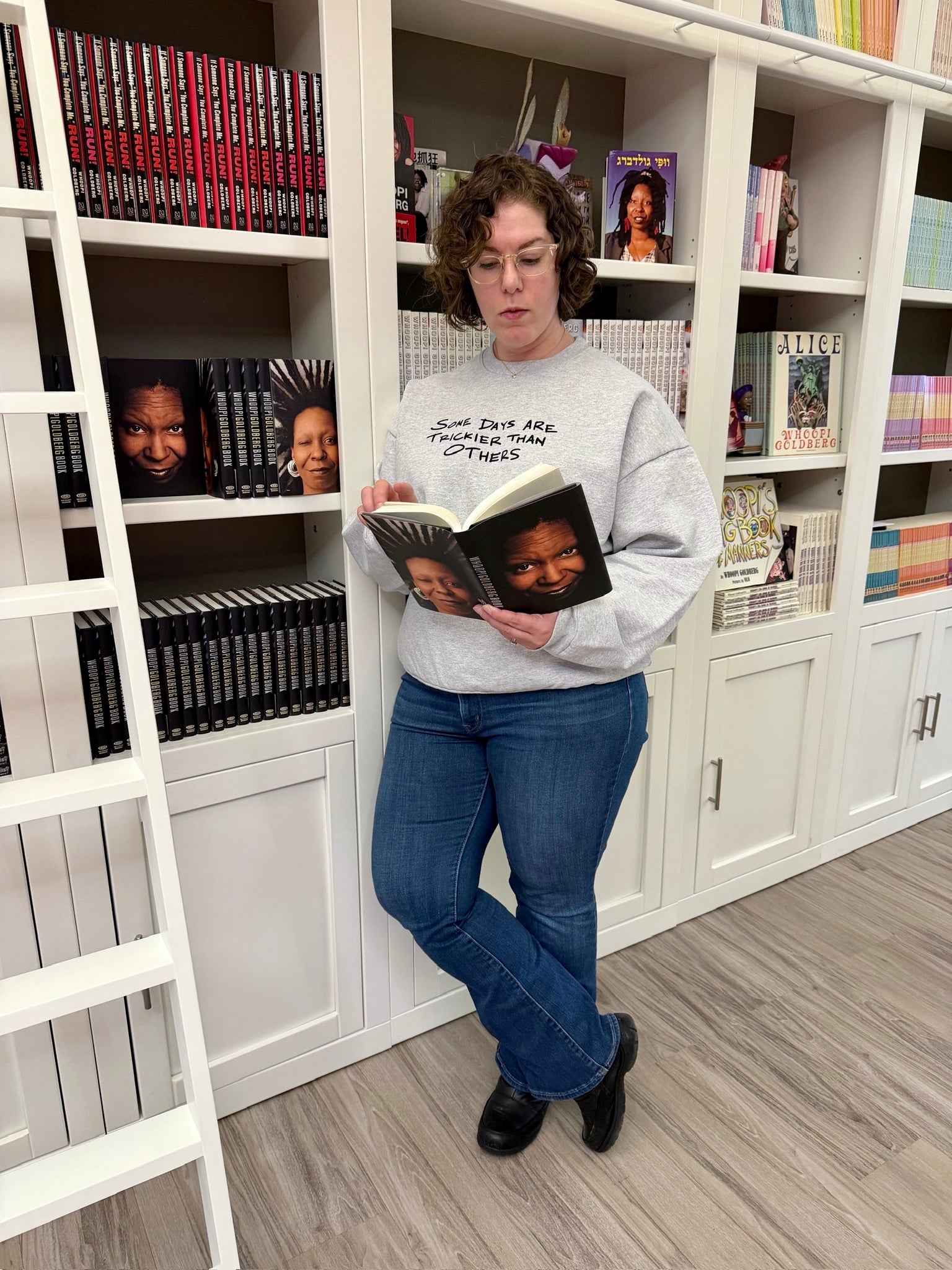 Person reading a book in a library setting