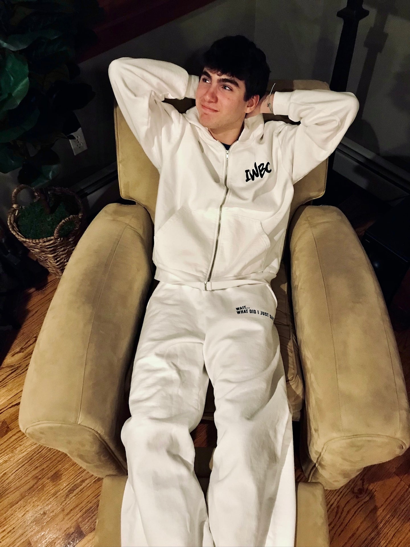 Person wearing a white hoodie with 'IWBC' logo sitting in a chair.